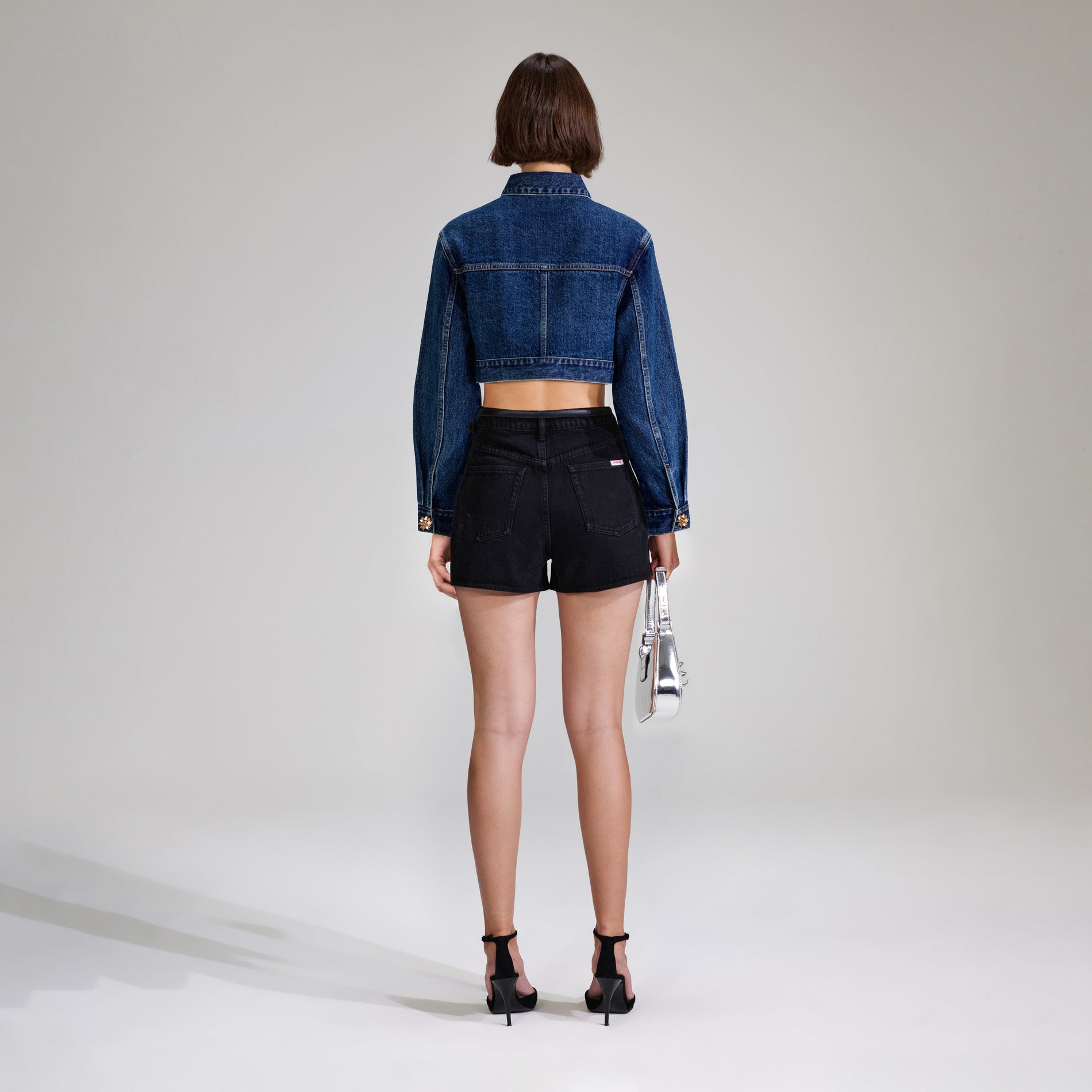 A woman wearing the Black Denim High Rise Short