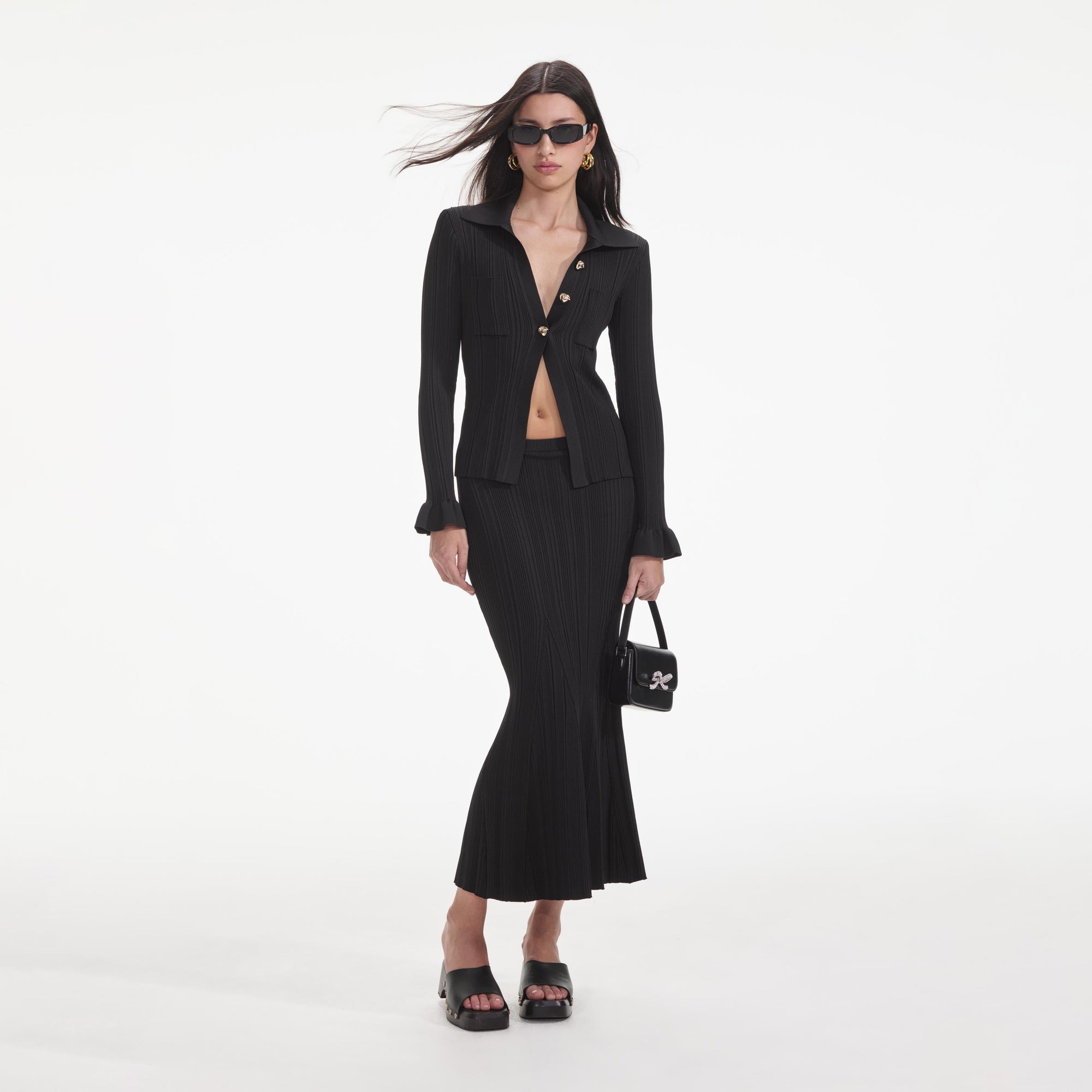 Front view of a woman wearing the Black Ribbed Midi Skirt