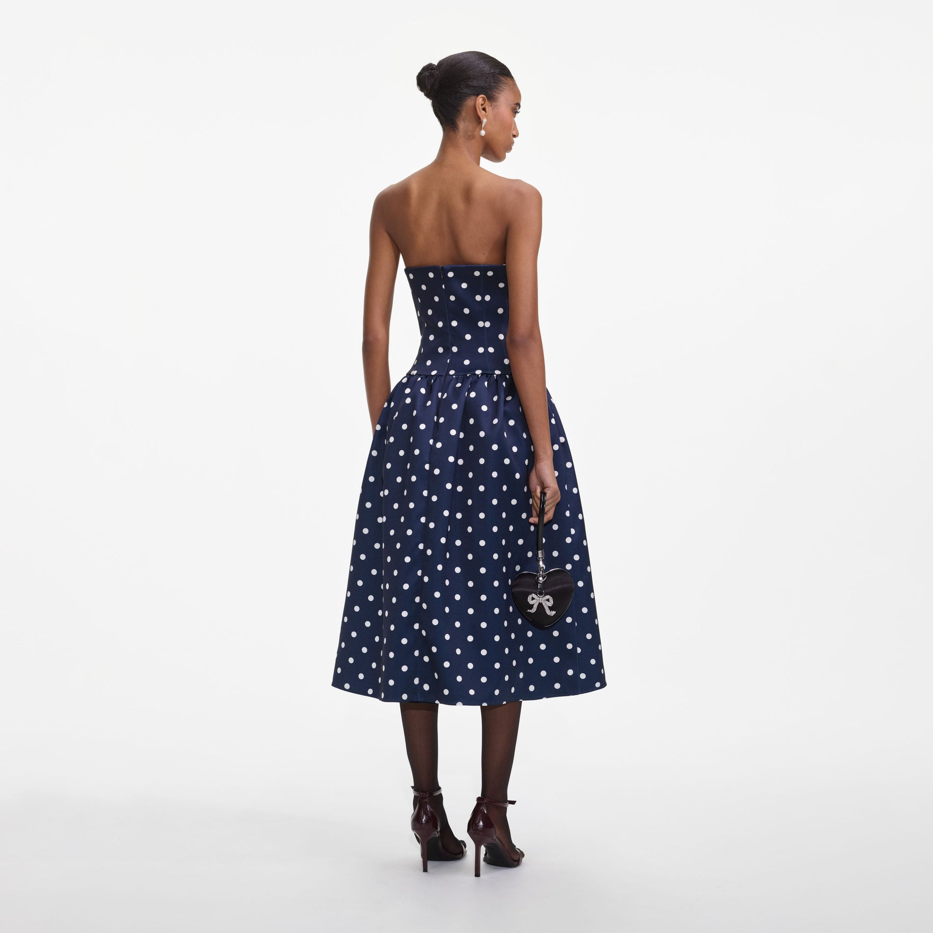 Back view of a woman wearing the Navy Polka Dot Satin Midi Dress