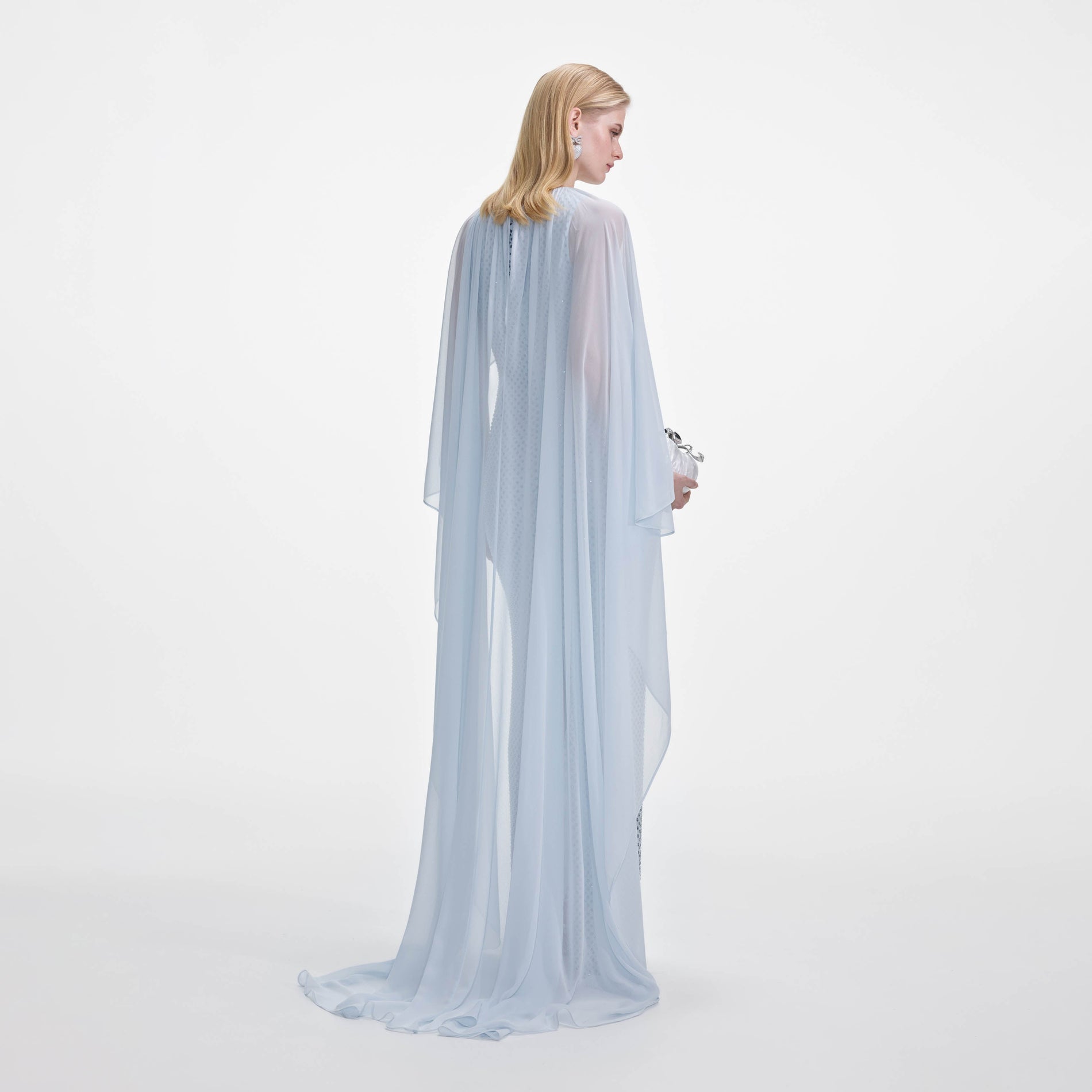 Back view of a woman wearing the Pale Blue Rhinestone Cape Maxi Dress