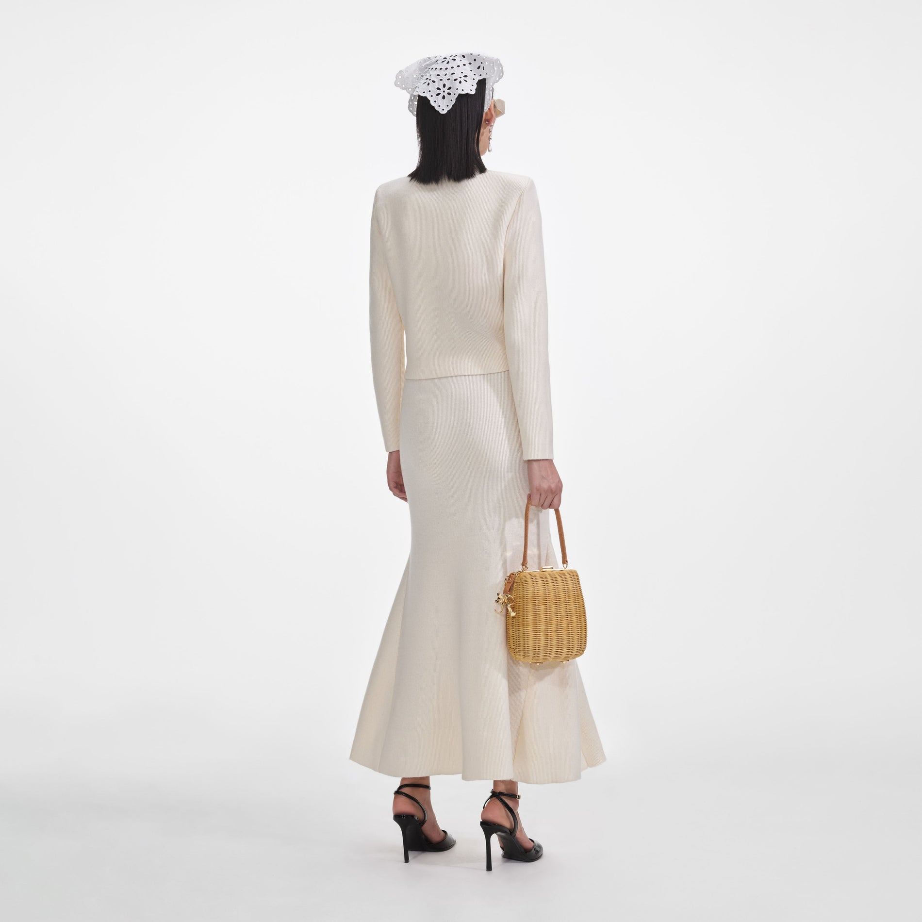 Back view of a woman wearing the Cream Flared Knit Midi Skirt