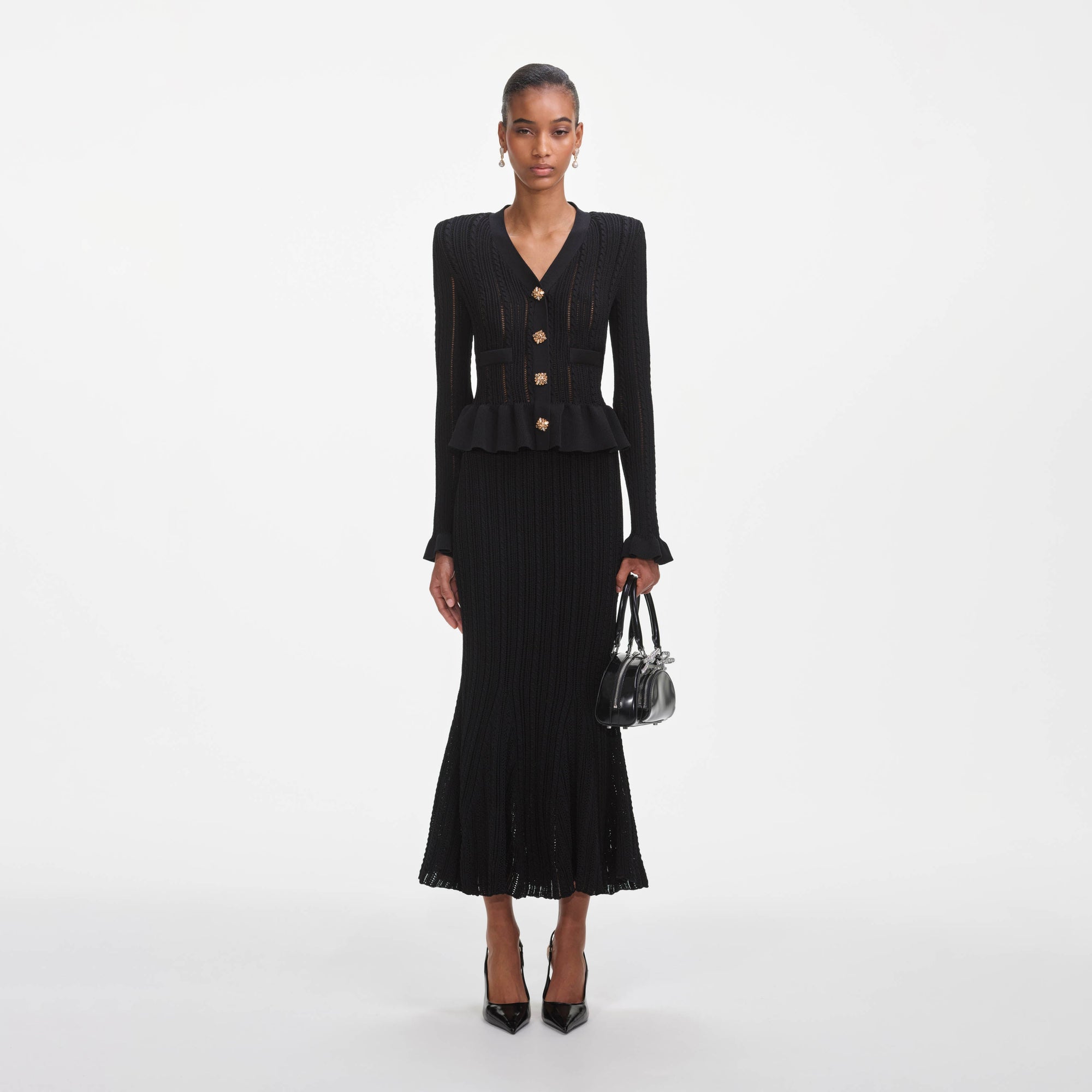 Front view of a woman wearing the Black Knit Peplum Midi Dress