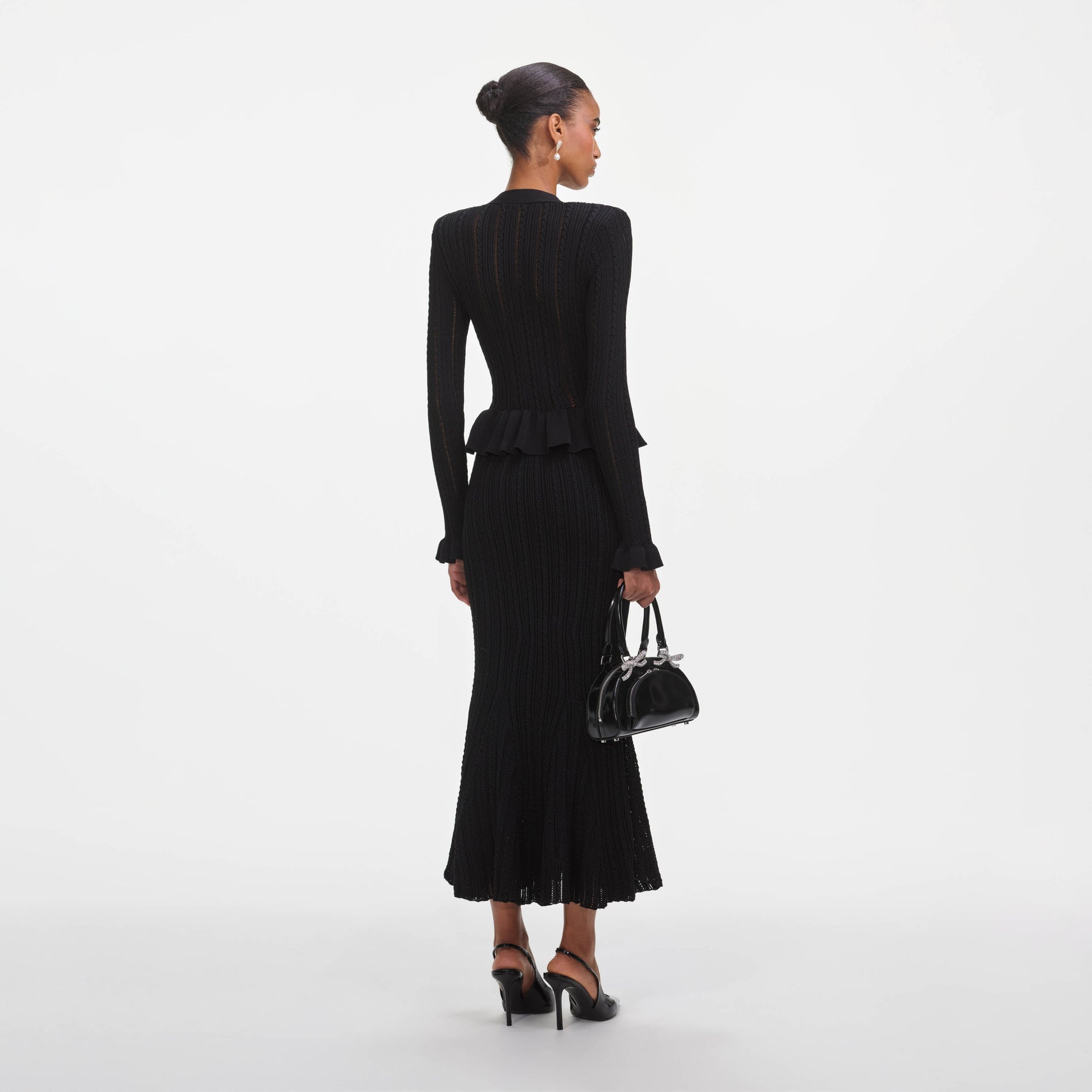 Back view of a woman wearing the Black Knit Peplum Midi Dress