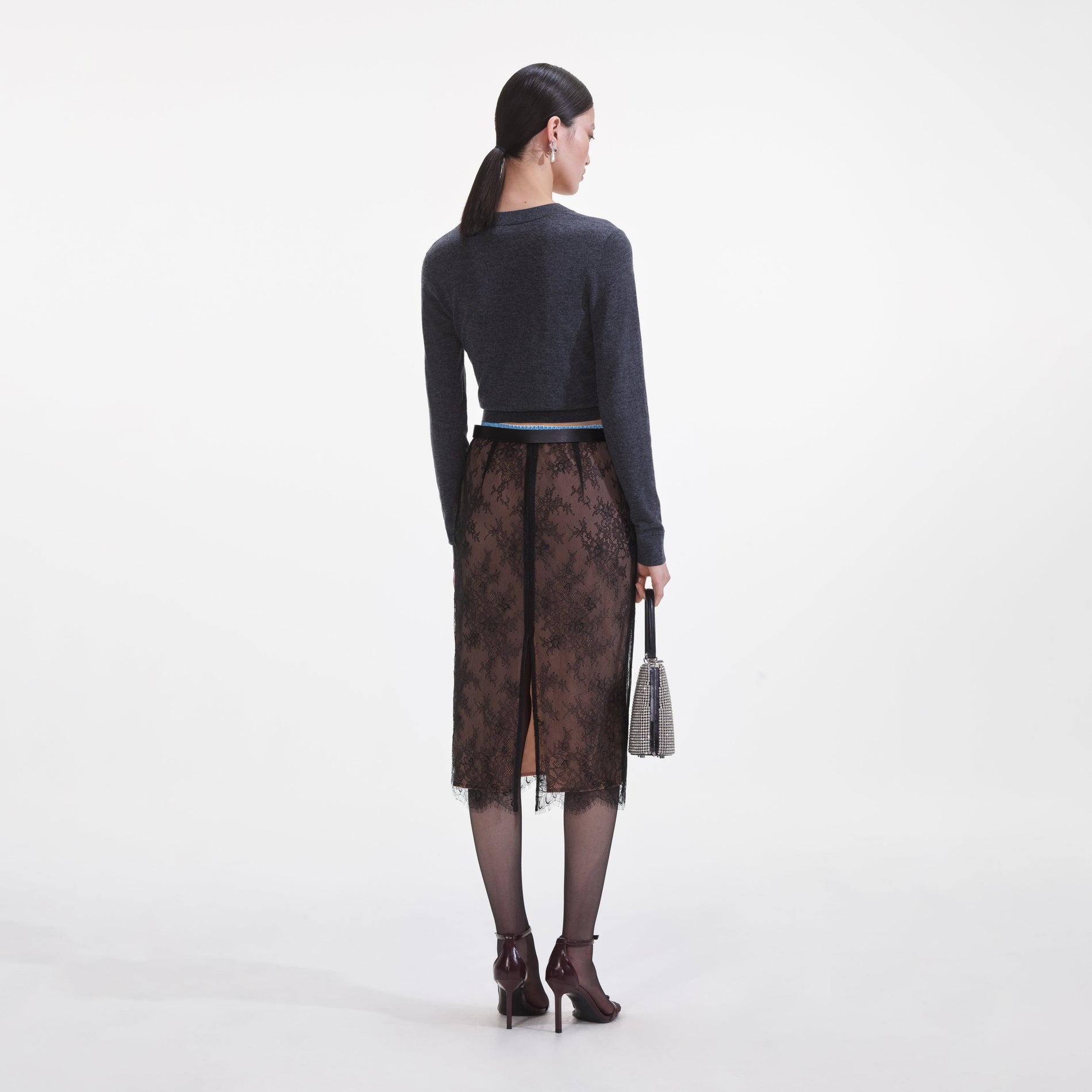 Back view of a woman wearing the Black Lace Midi Skirt