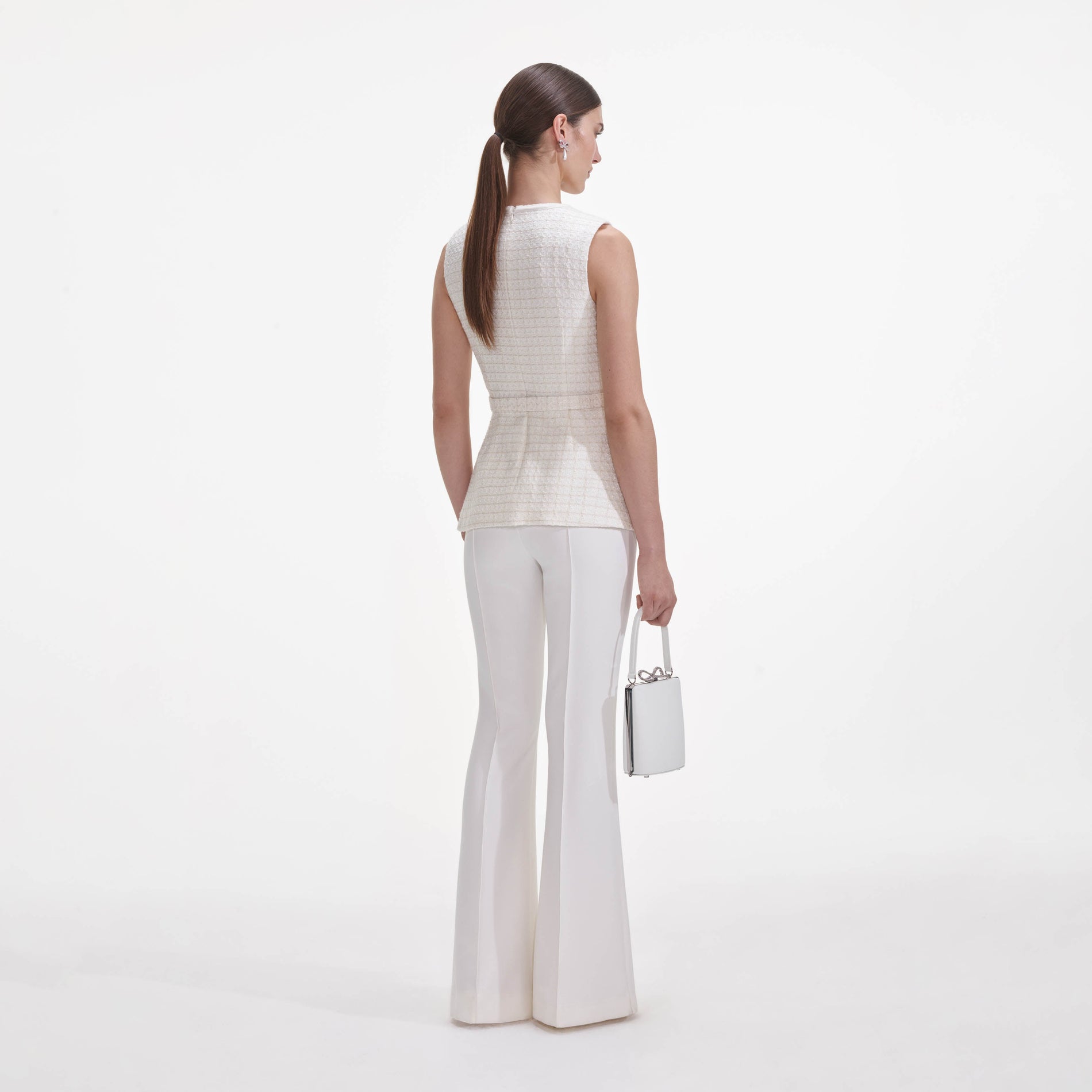 Back view of a woman wearing the Cream Boucle Bow Jumpsuit