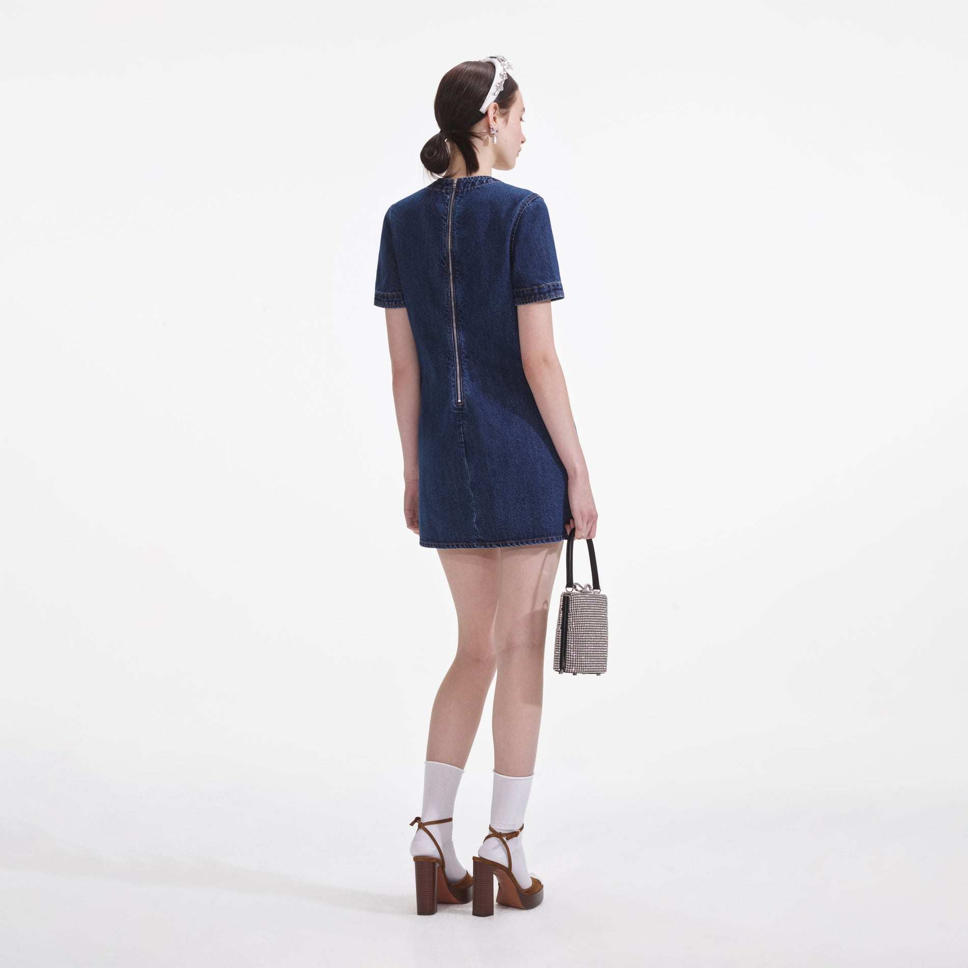 Back view of a woman wearing the Denim Bow Mini Dress