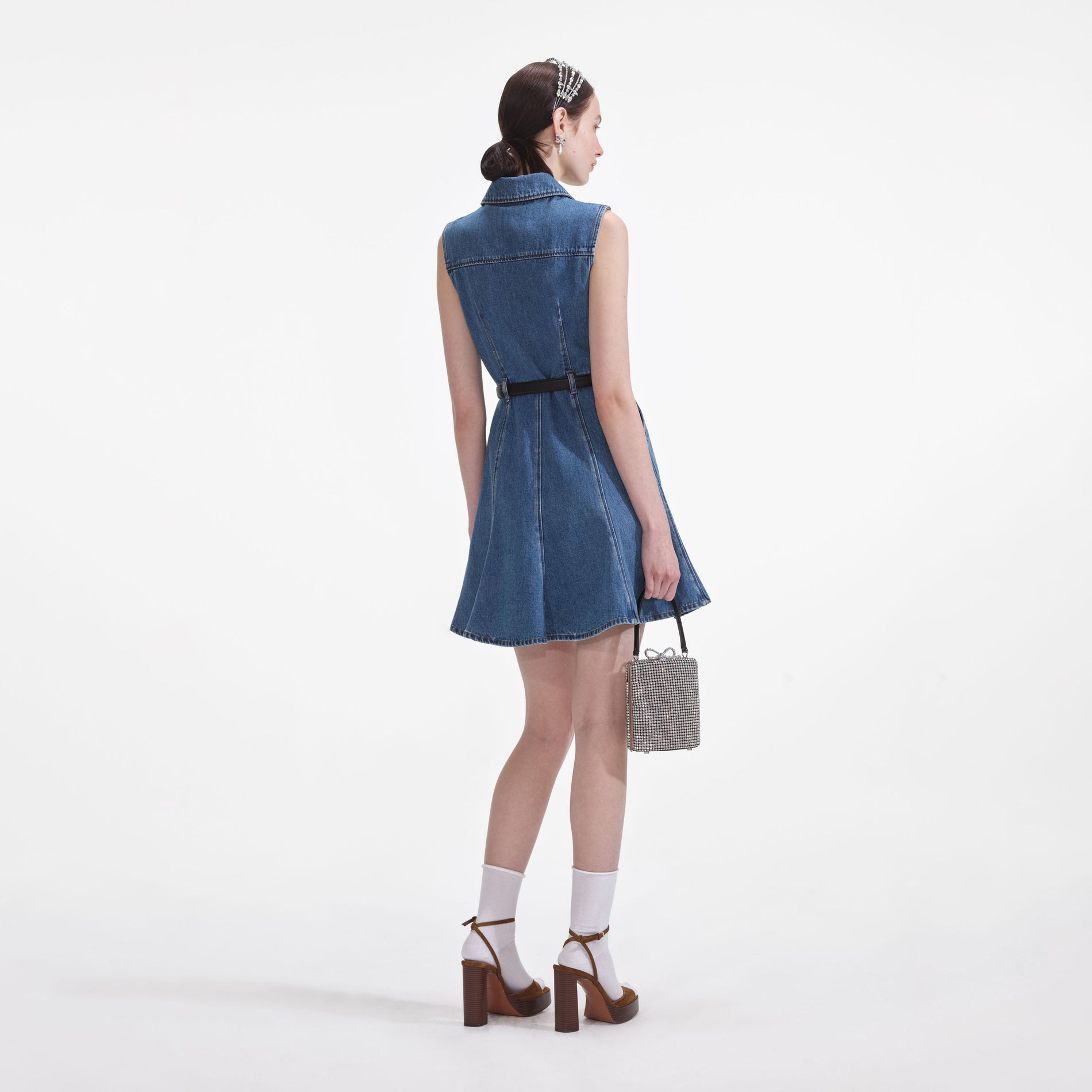 Back view of a woman wearing the Denim Sleeveless Pearl Mini Dress