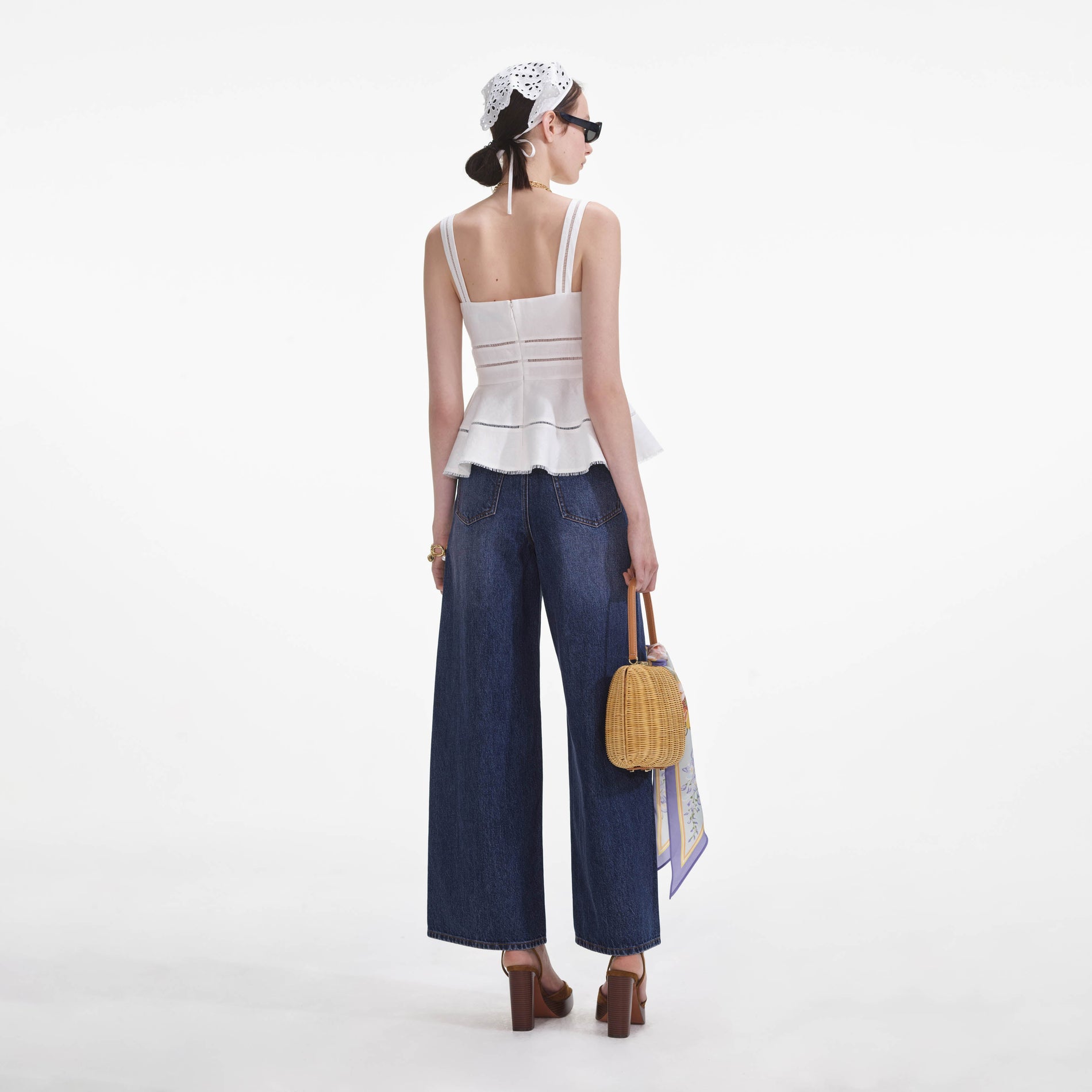 Back view of a woman wearing the White Linen Peplum Top