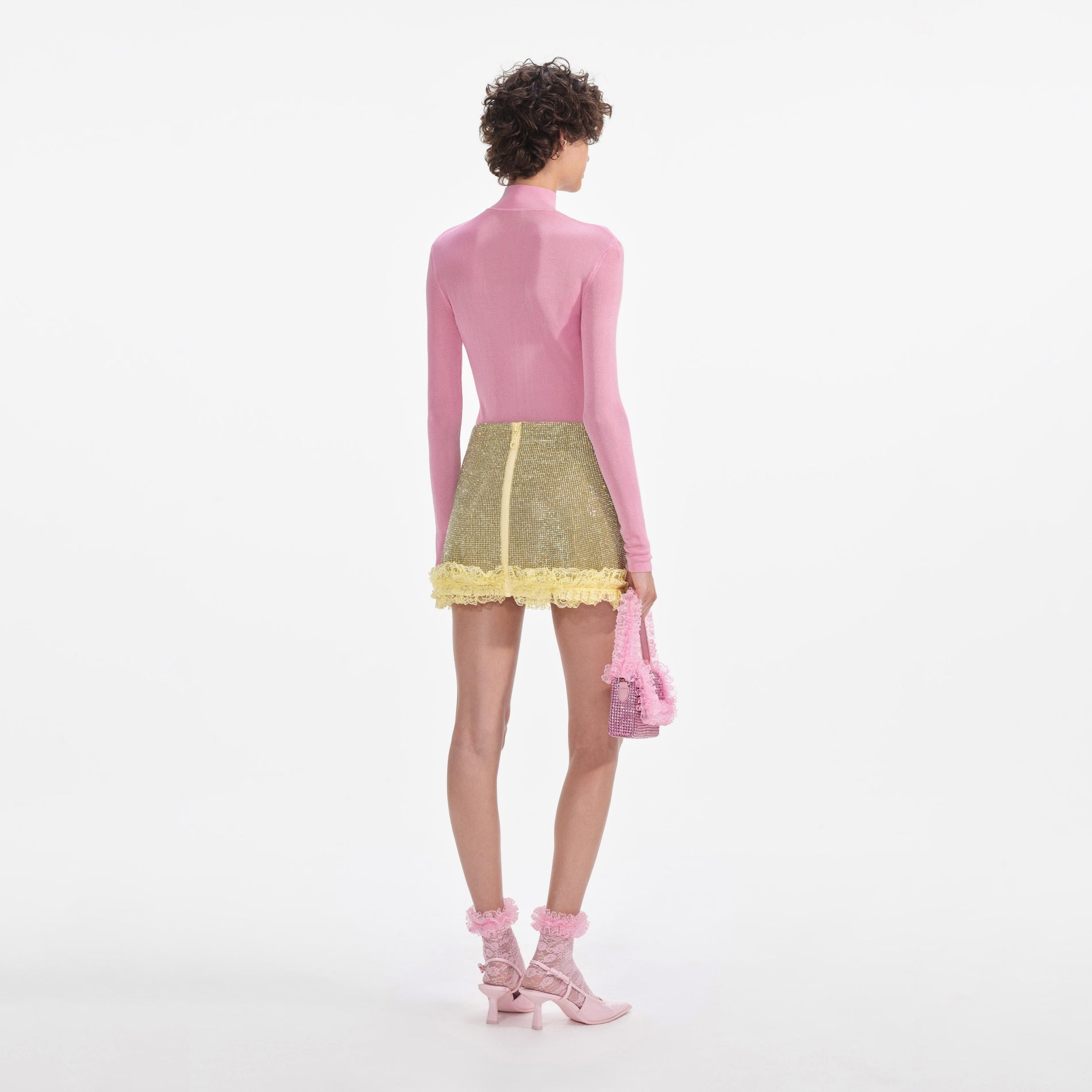 Back view of a woman wearing the Yellow Crystal Chainmail Mini Skirt