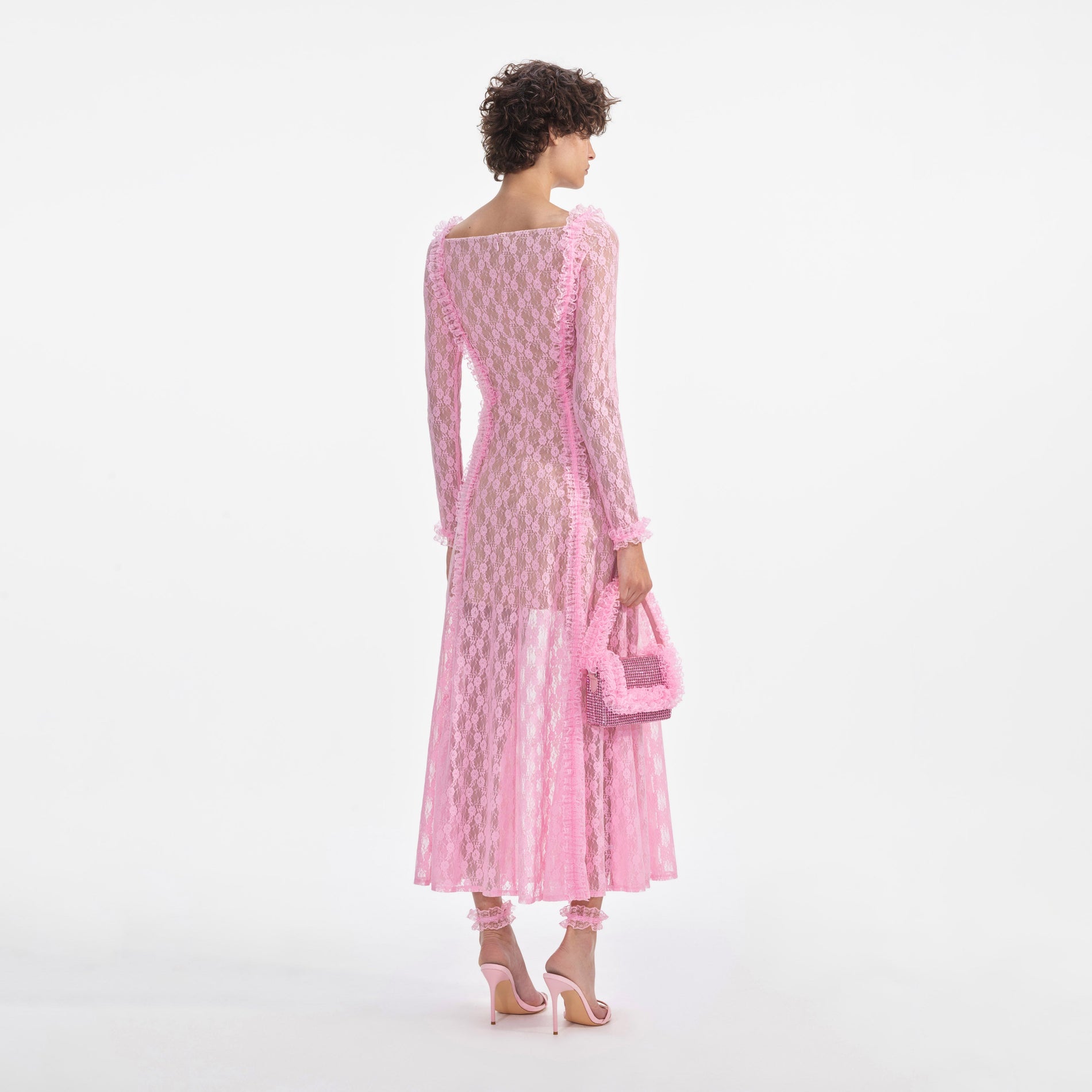 Back view of a woman wearing the Pink Lace Ruffle Midi Dress