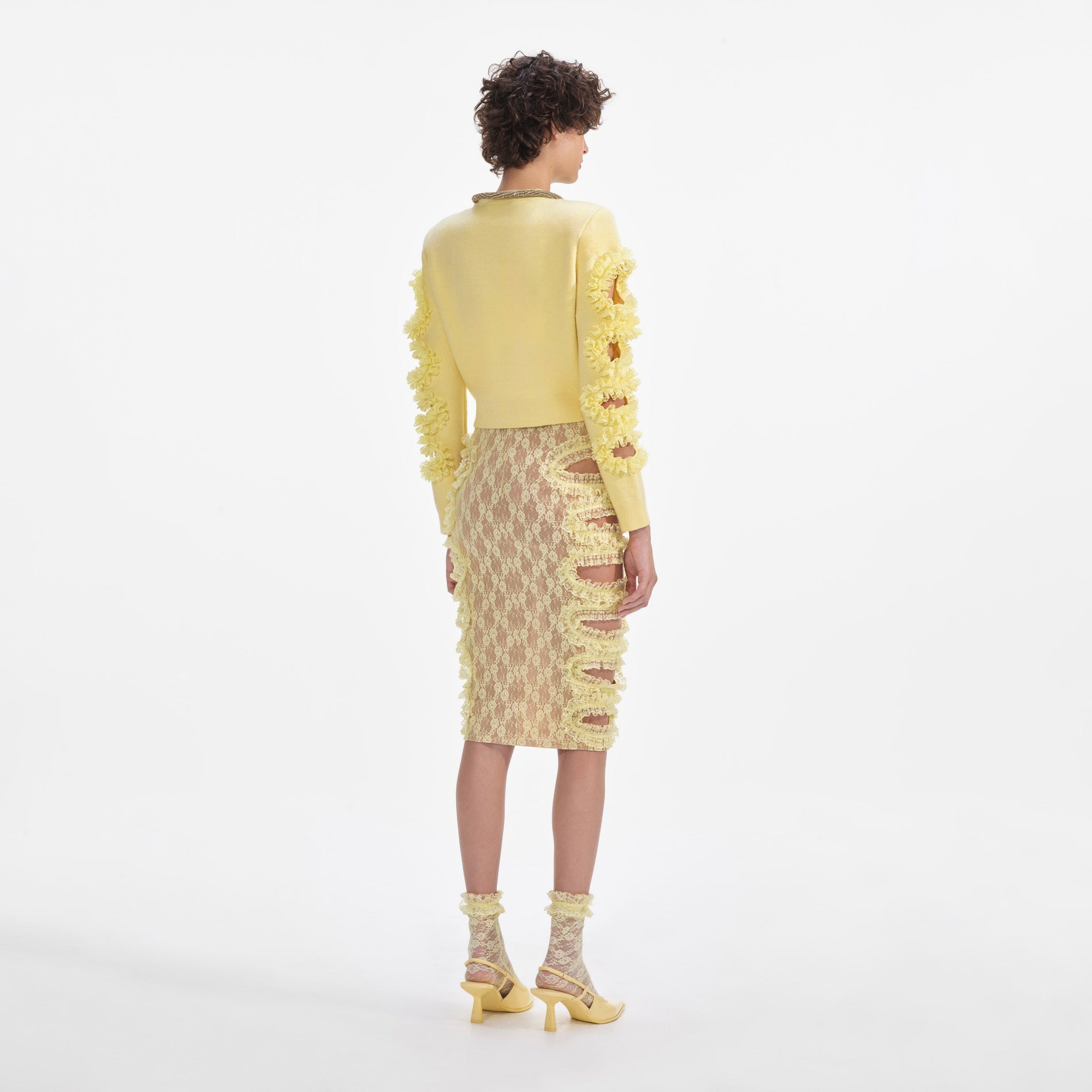 Back view of a woman wearing the Yellow Lace Cut Out Midi Skirt