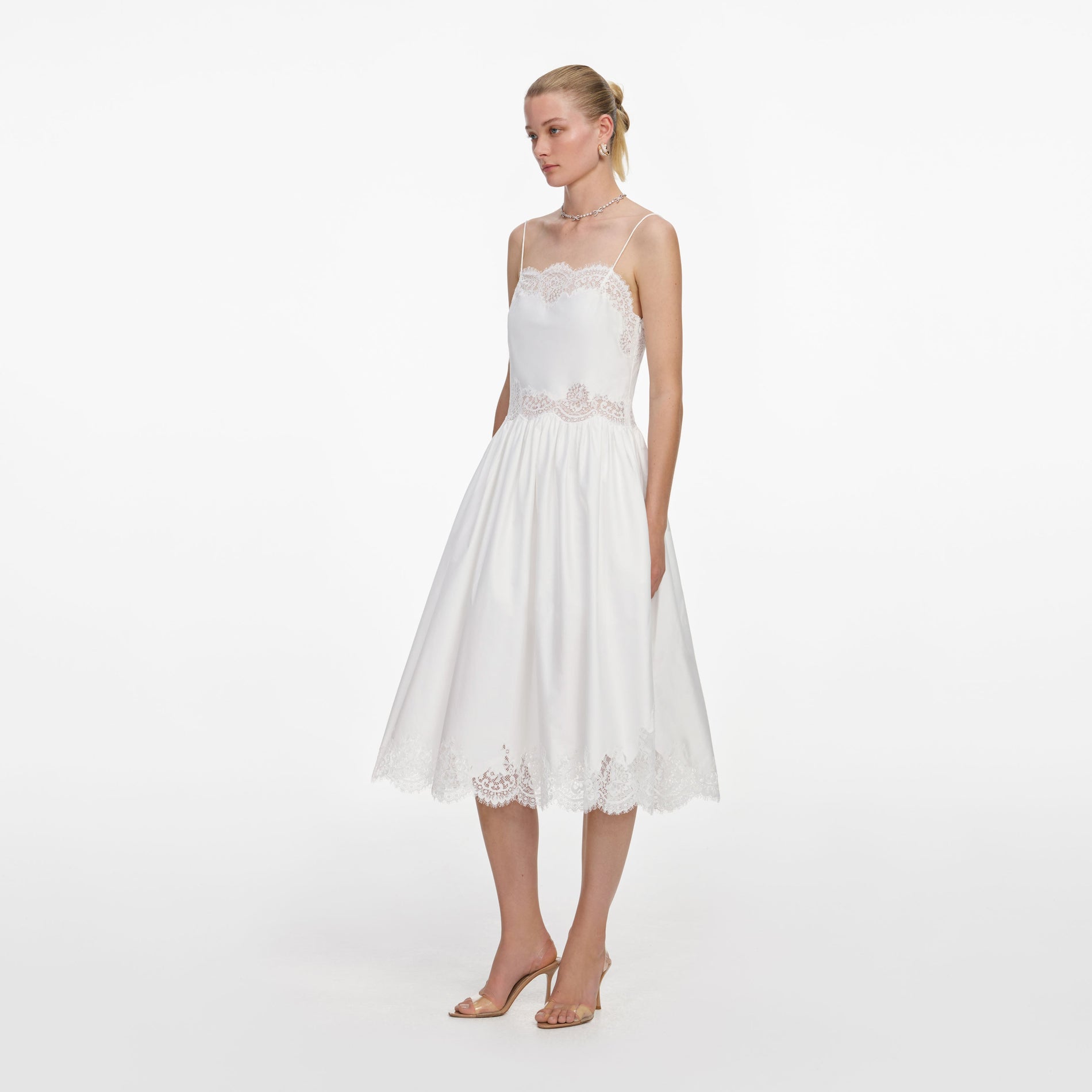 Side view of a woman wearing the White Cotton Lace Trim Midi Dress