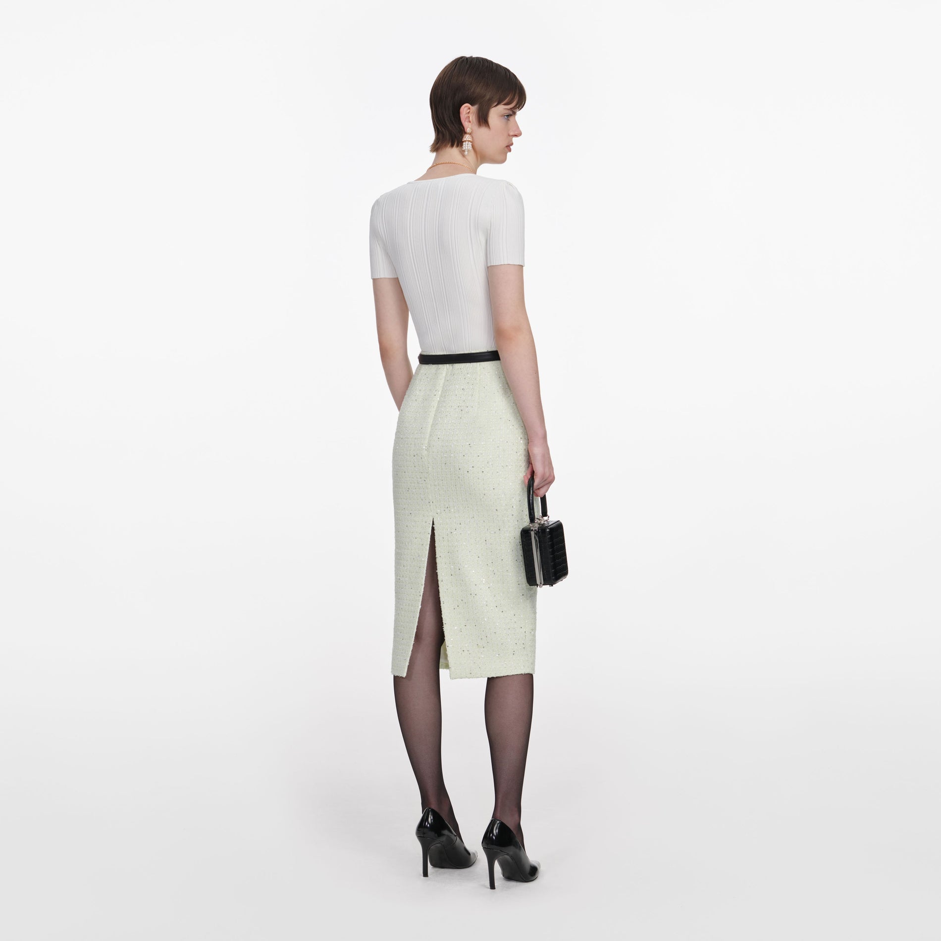 Back view of a woman wearing the Lime Boucle Midi Skirt
