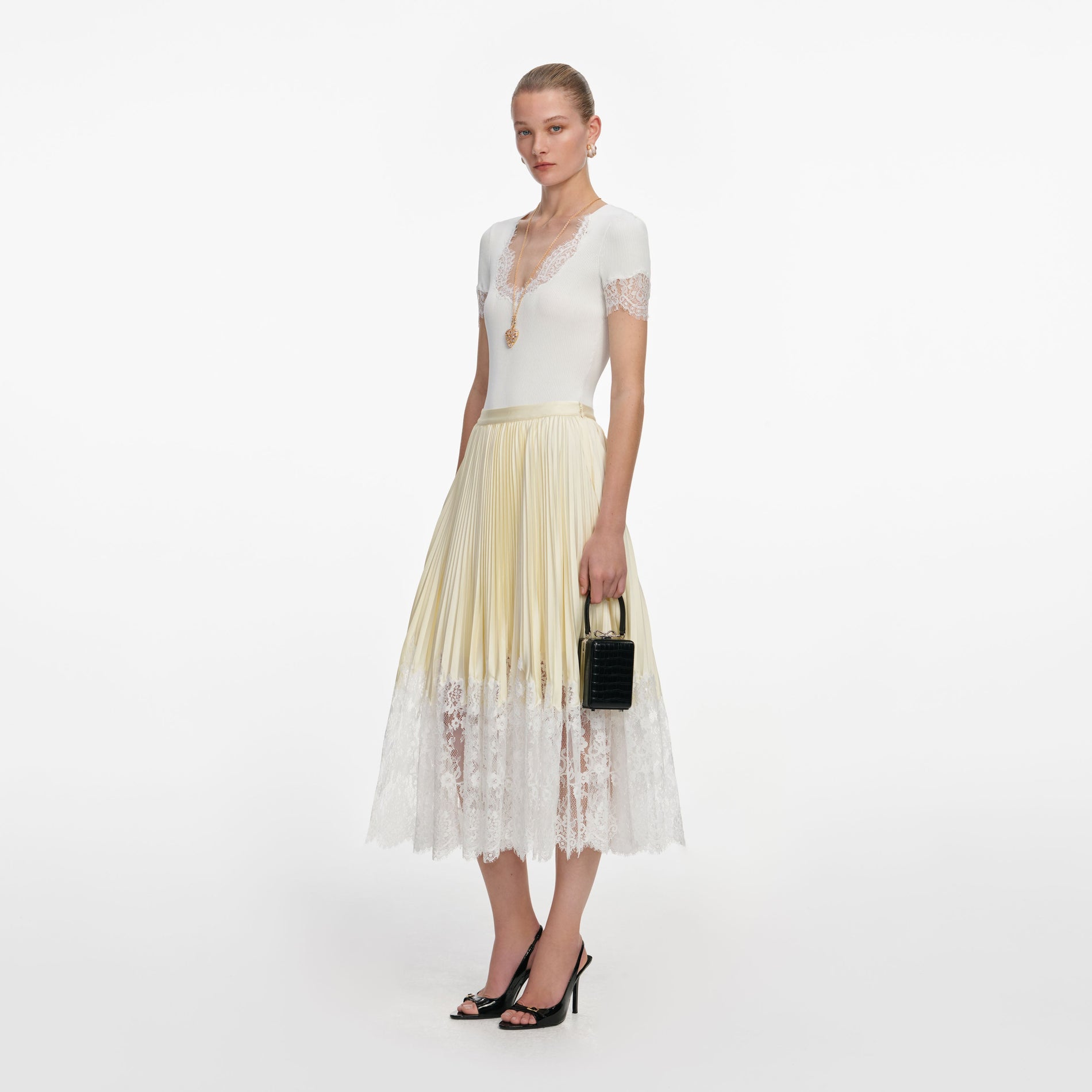 Side view of a woman wearing the Yellow Satin Lace Midi Skirt