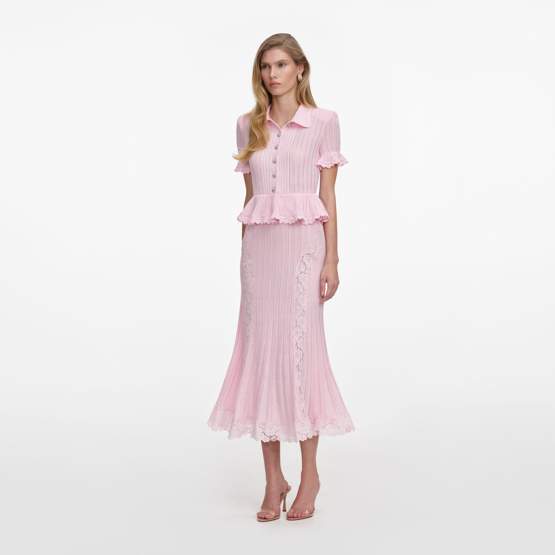 Side view of a woman wearing the Pink Pointelle Peplum Knit Midi Dress