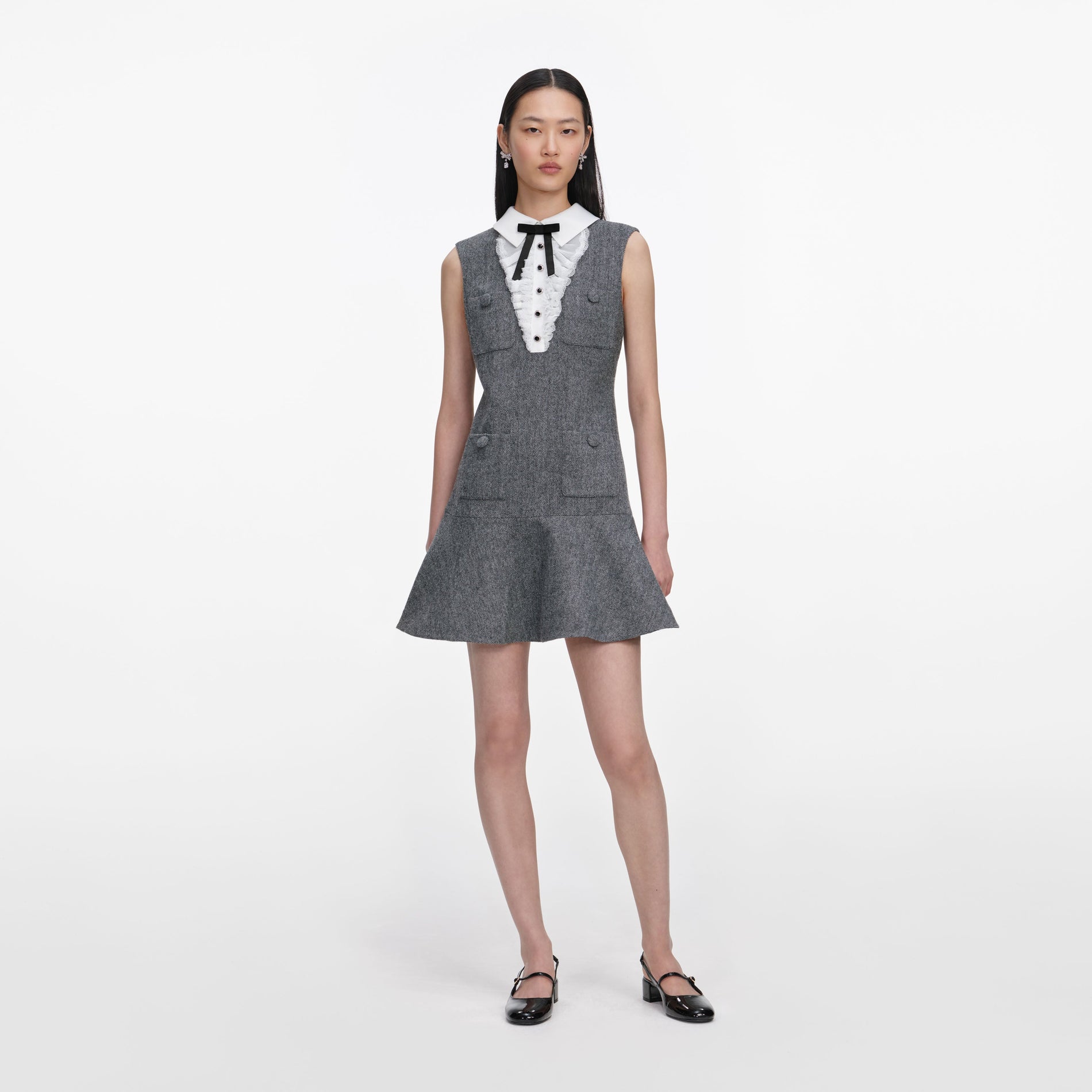 Front view of a woman wearing the Grey Herringbone Lace Bib Mini Dress