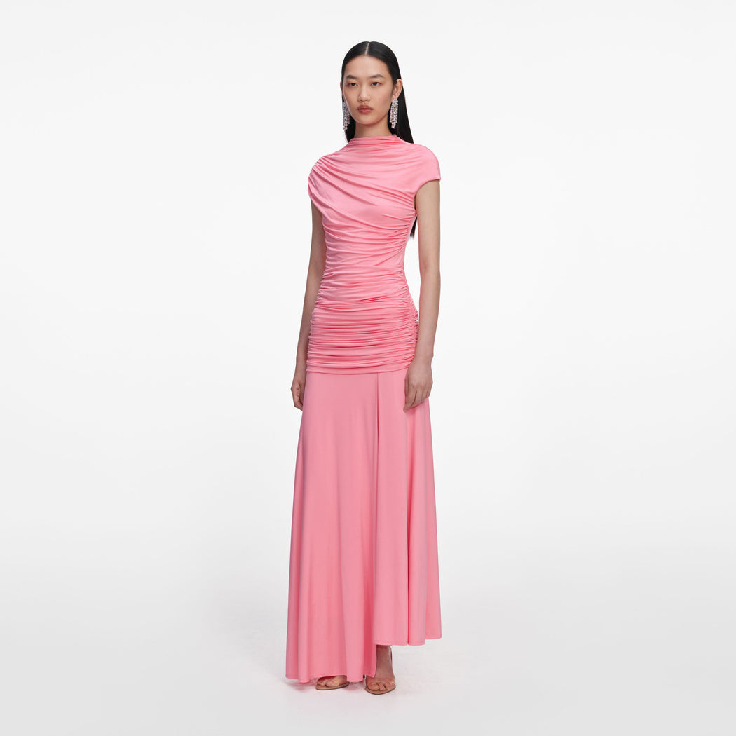 Woman in a pink ruched top and matching long skirt with clear strap heels