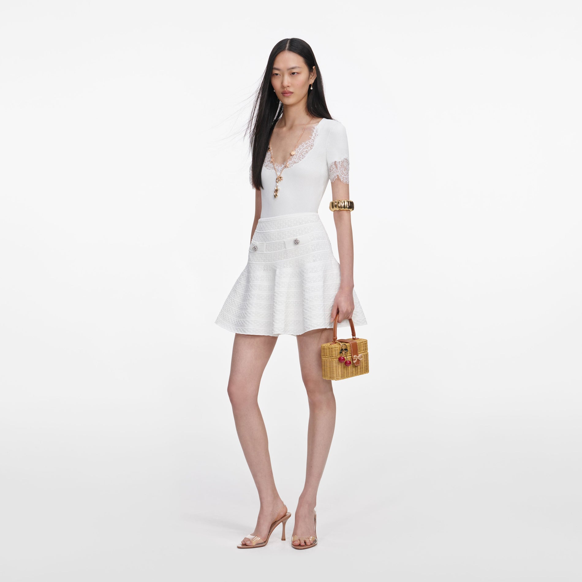 Side view of a woman wearing the White Pointelle Knit Mini Skirt