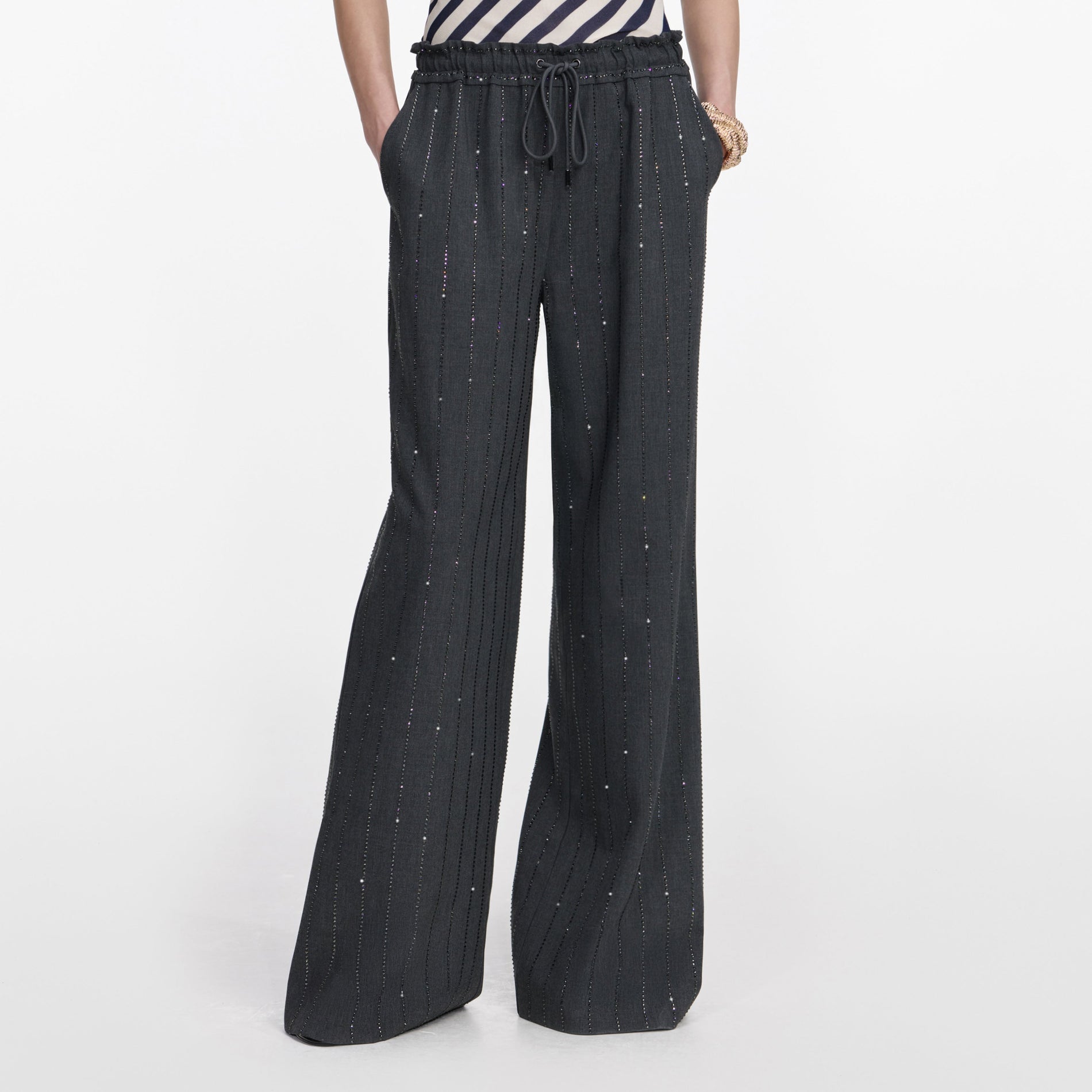 Side view of a woman wearing the Grey Rhinestone Pinstripe Trousers