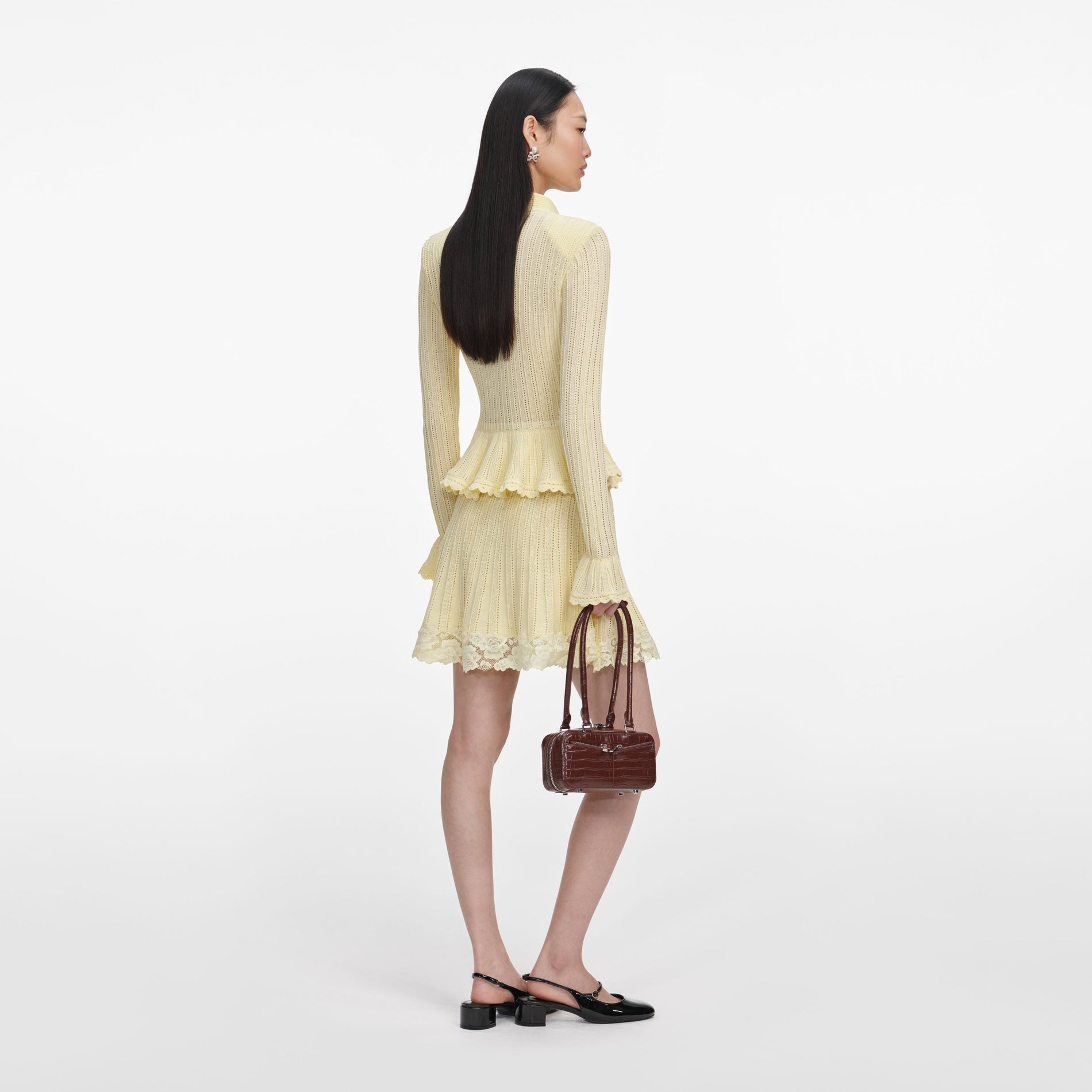 Back view of a woman wearing the Yellow Pointelle Peplum Knit Mini Dress