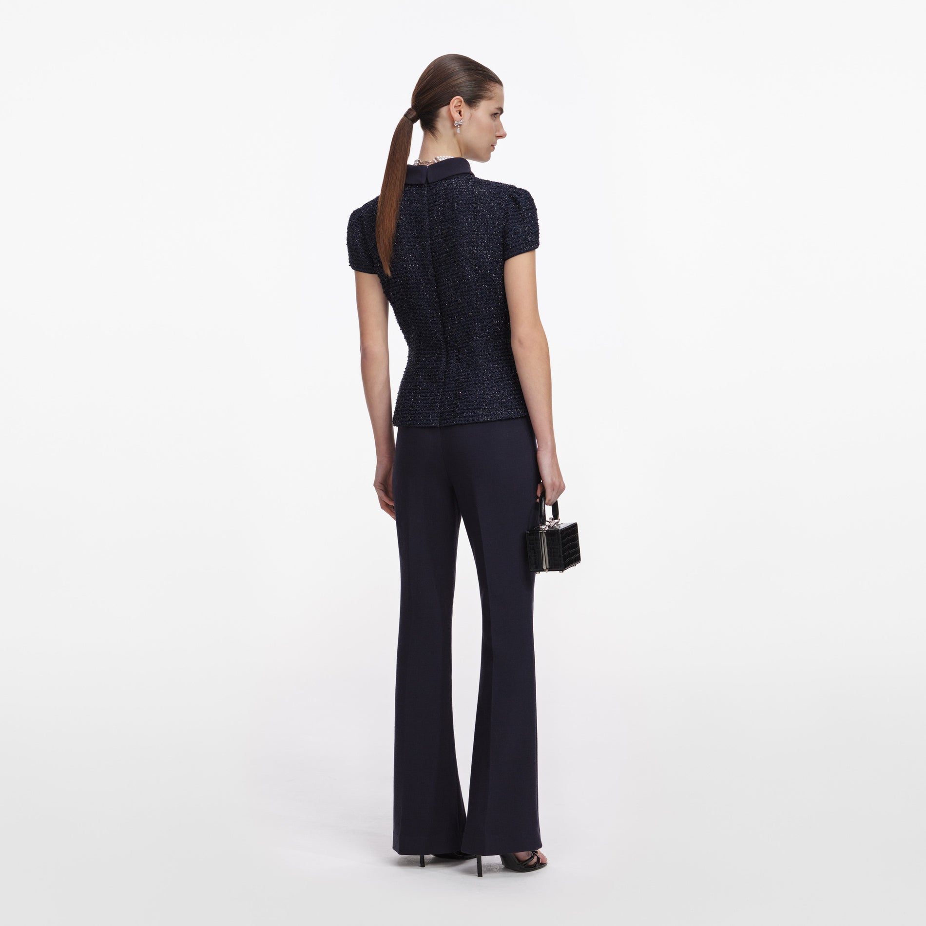 Back view of a woman wearing the Navy Metallic Boucle Jumpsuit
