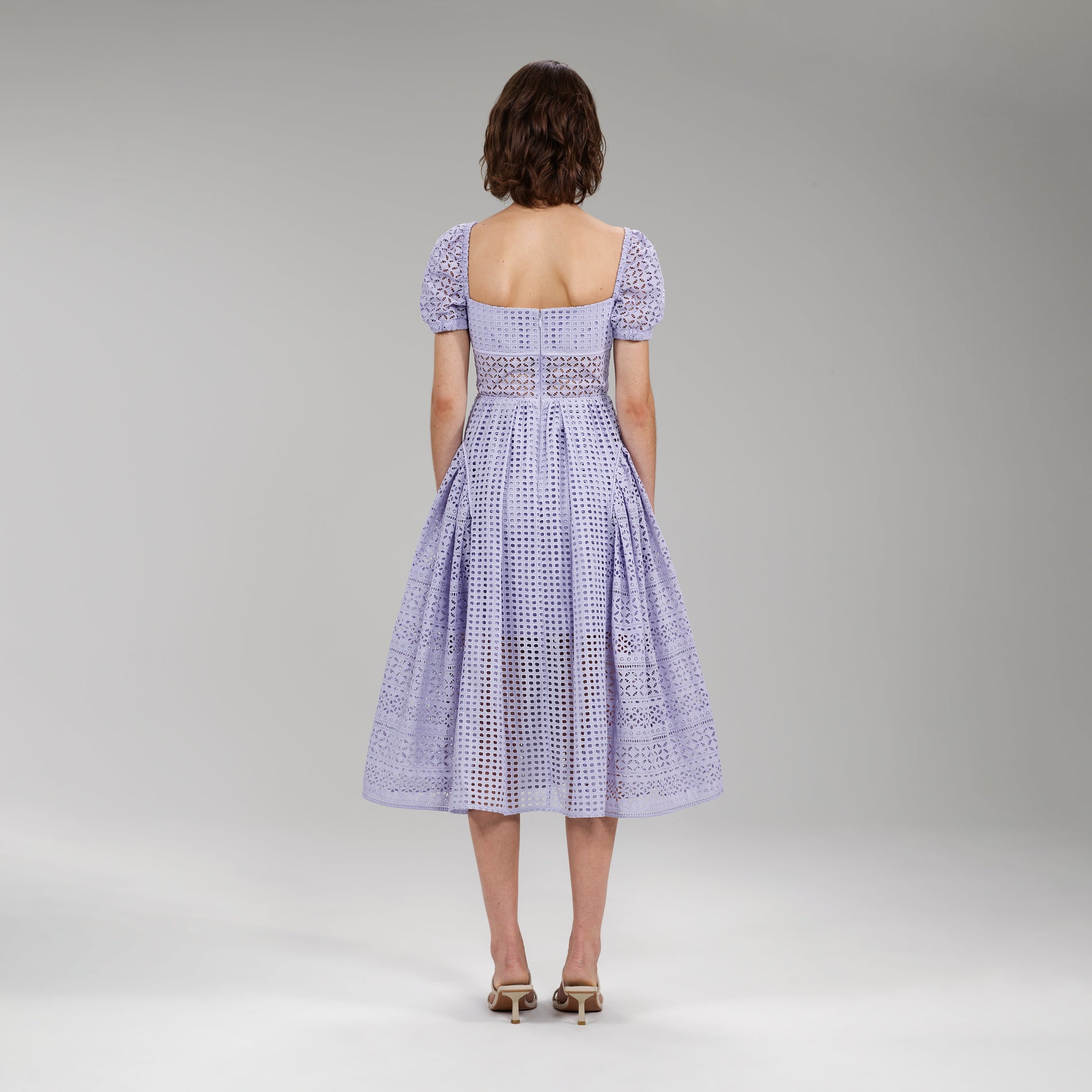 A woman wearing the Lilac Cotton Broderie Anglaise Midi Dress