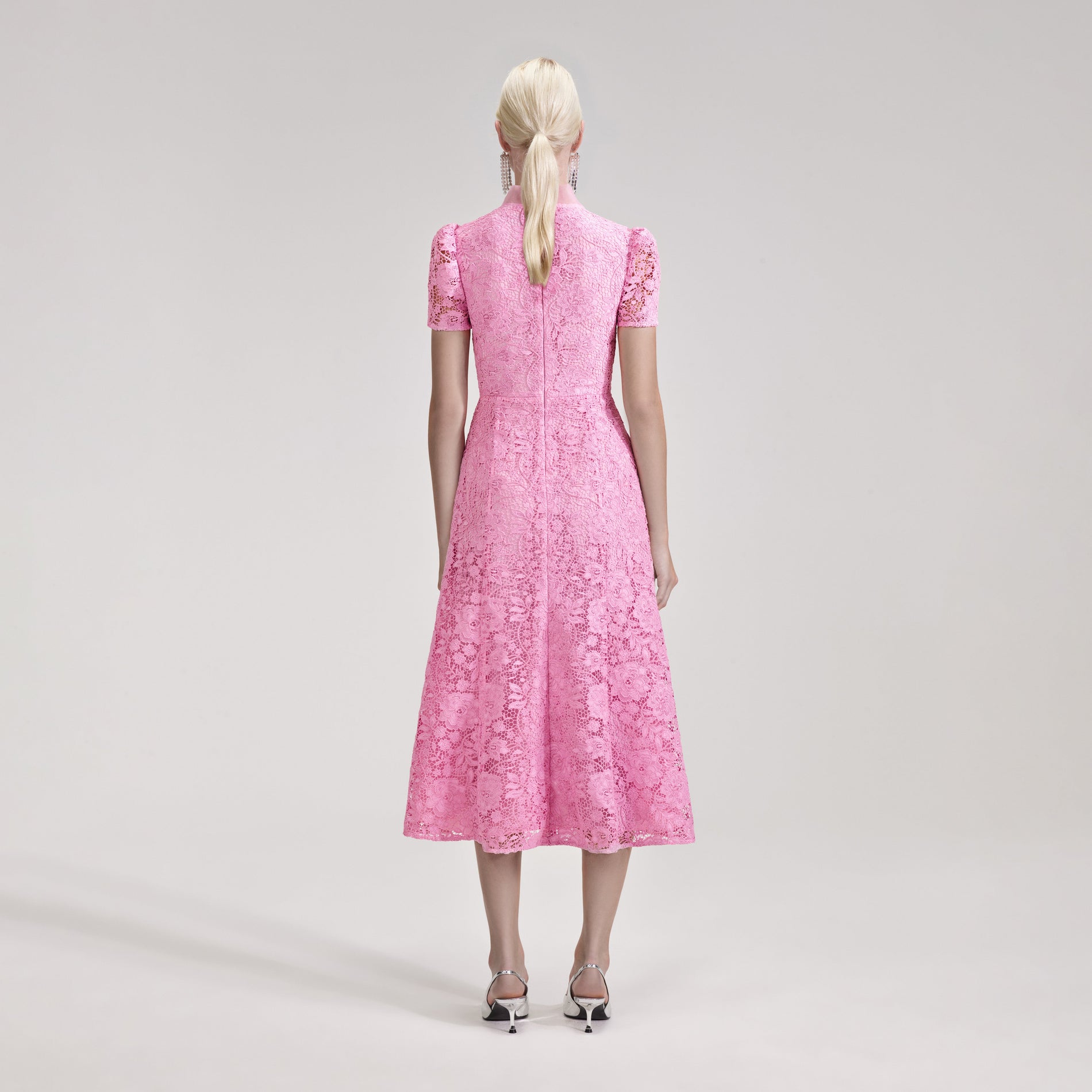 A woman wearing the Pink Cord Lace Crossover Midi Dress