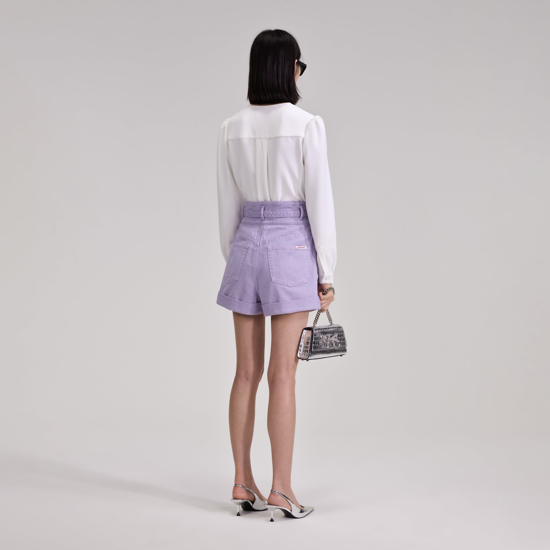 A woman wearing the Lilac Denim Shorts