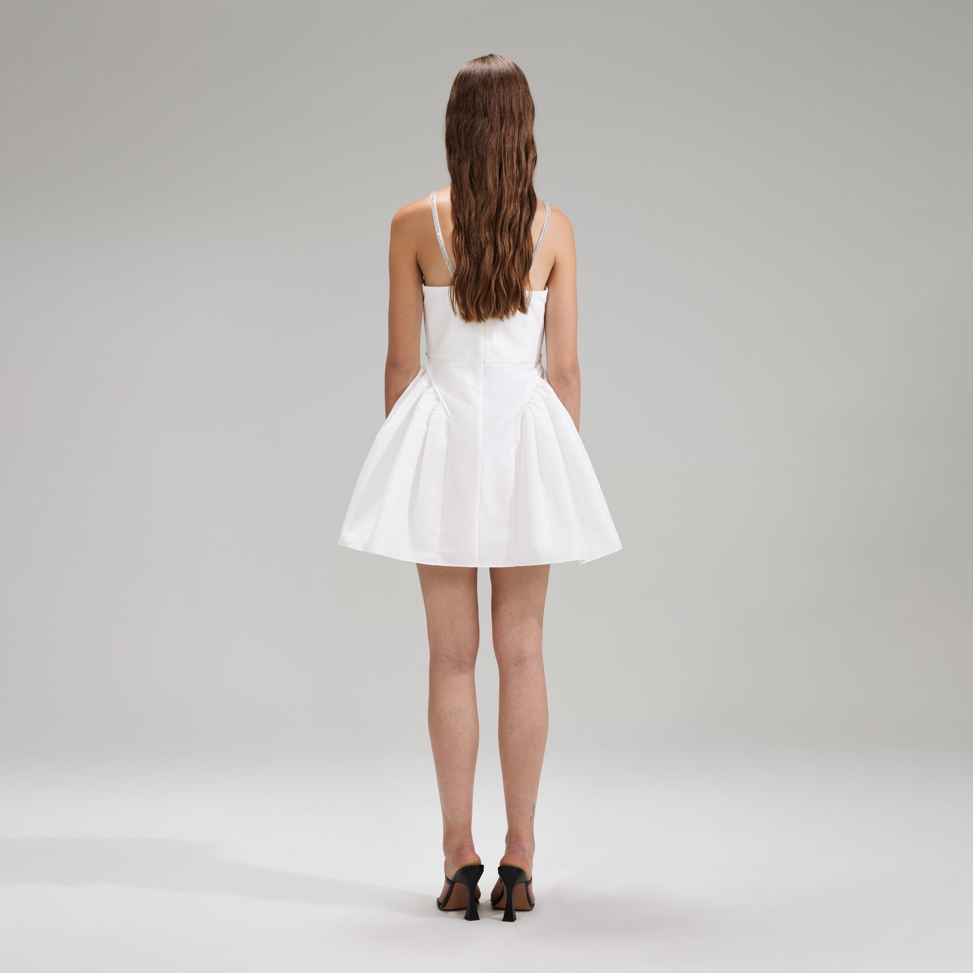 A woman wearing the White Taffeta Flared Mini Dress