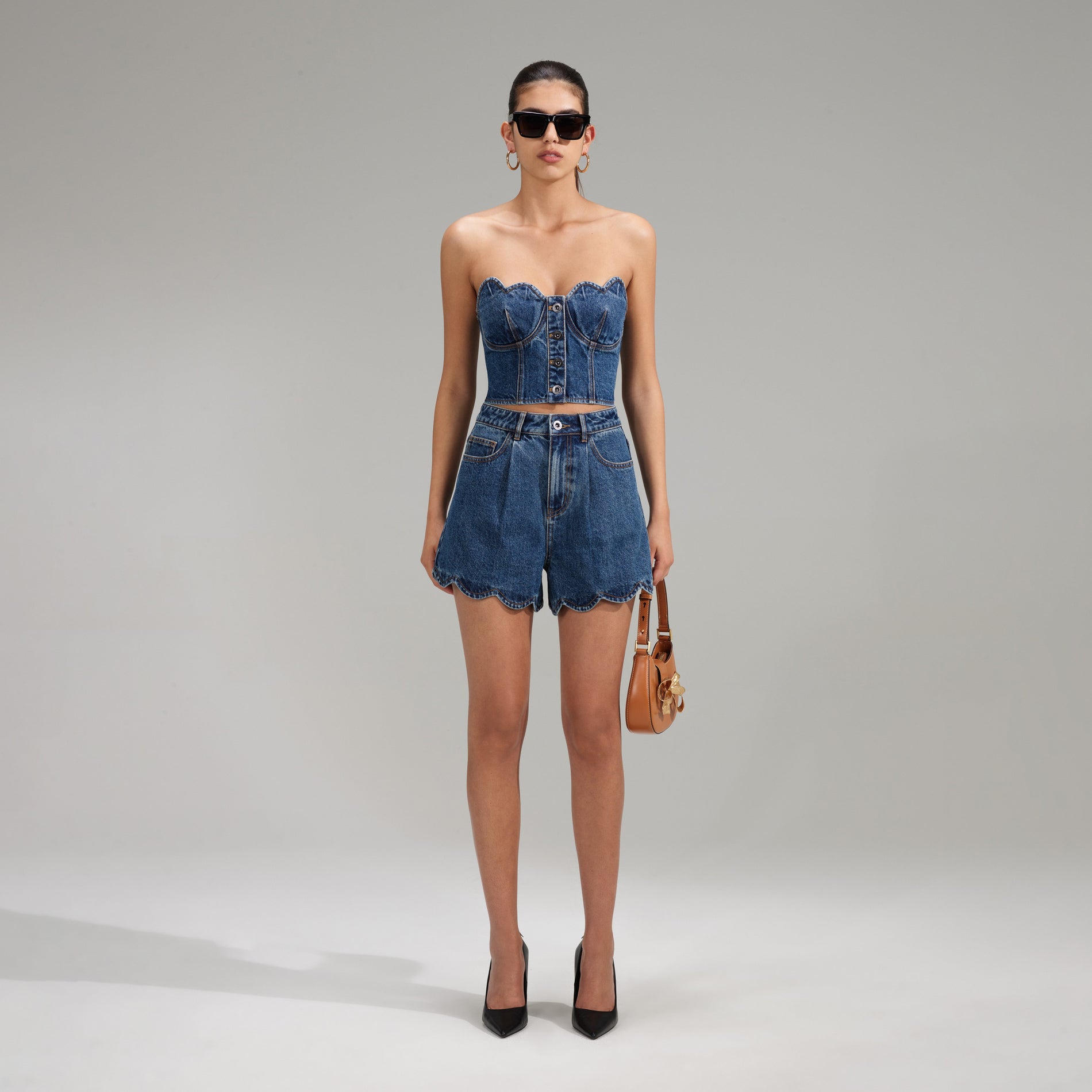 A woman wearing the Bandeau Denim Crop Top With Scalloped Edge
