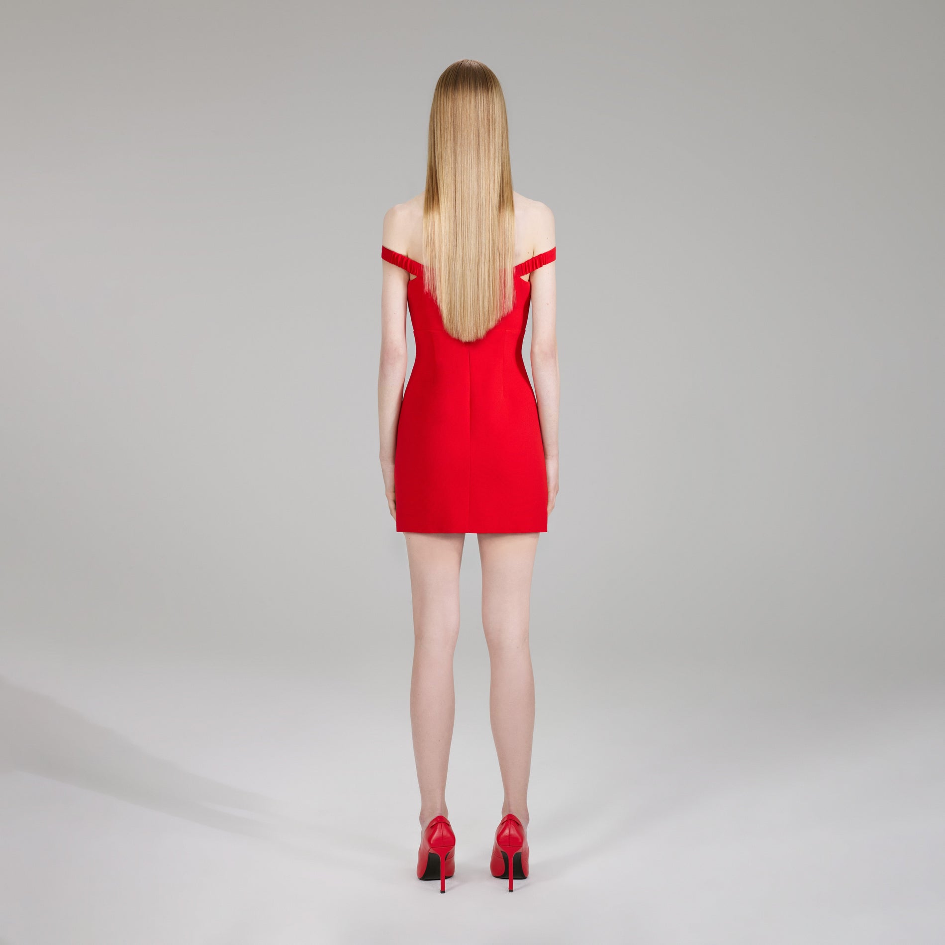 A woman wearing the Red Heavy Crepe Bow Mini Dress