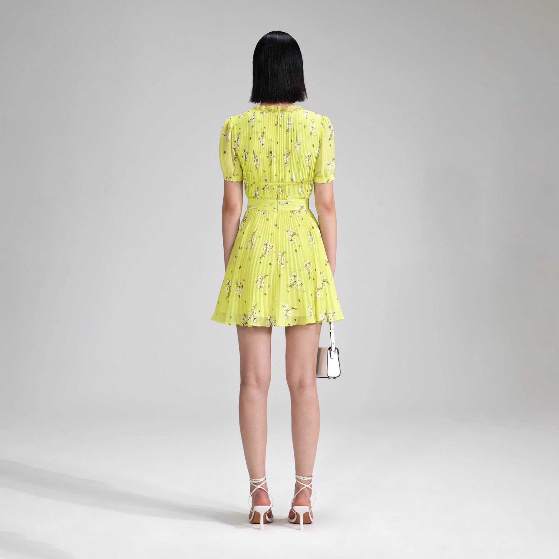 A woman wearing the Lime Floral Chiffon Mini Dress