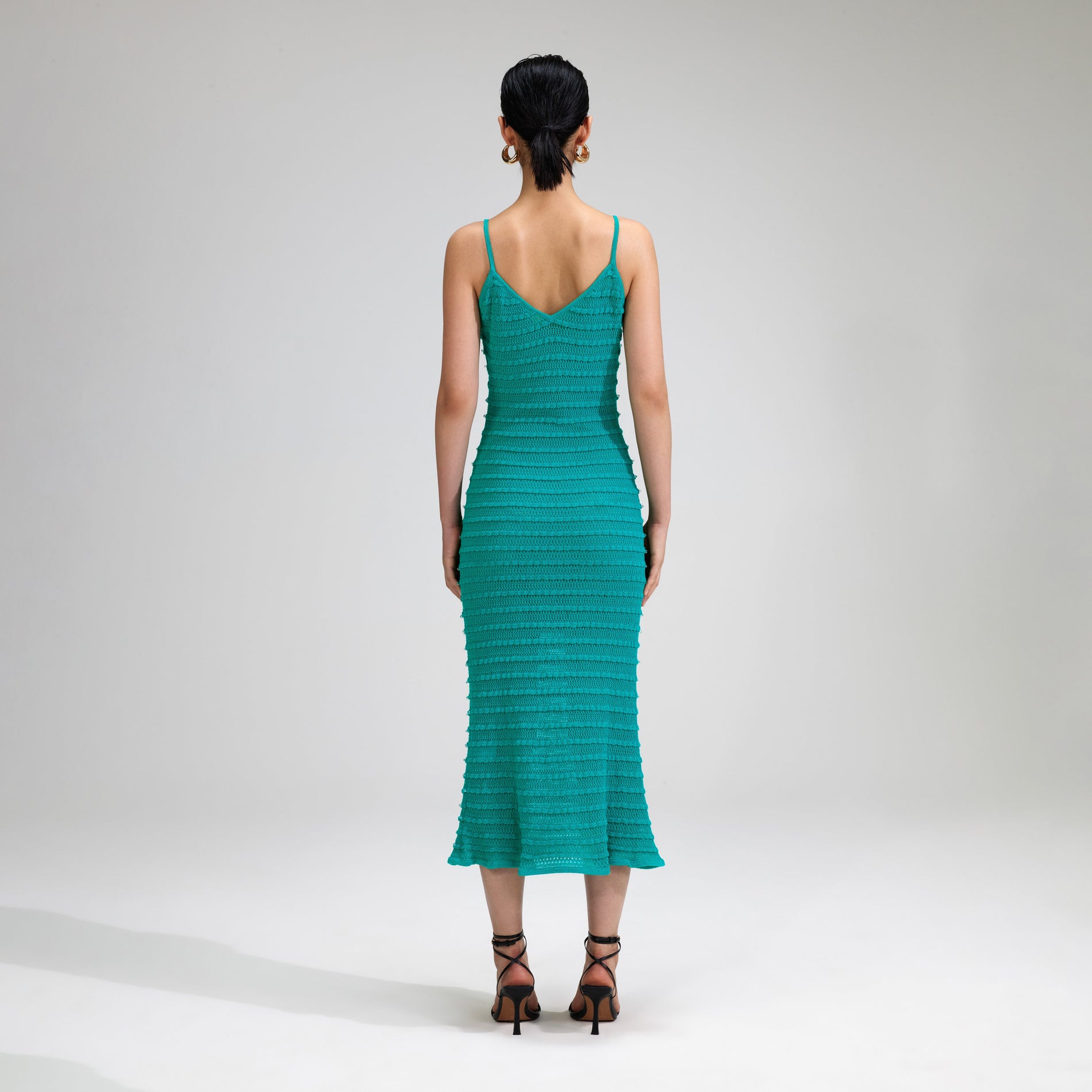 A woman wearing the Green Beaded Strappy Knit Midi Dress