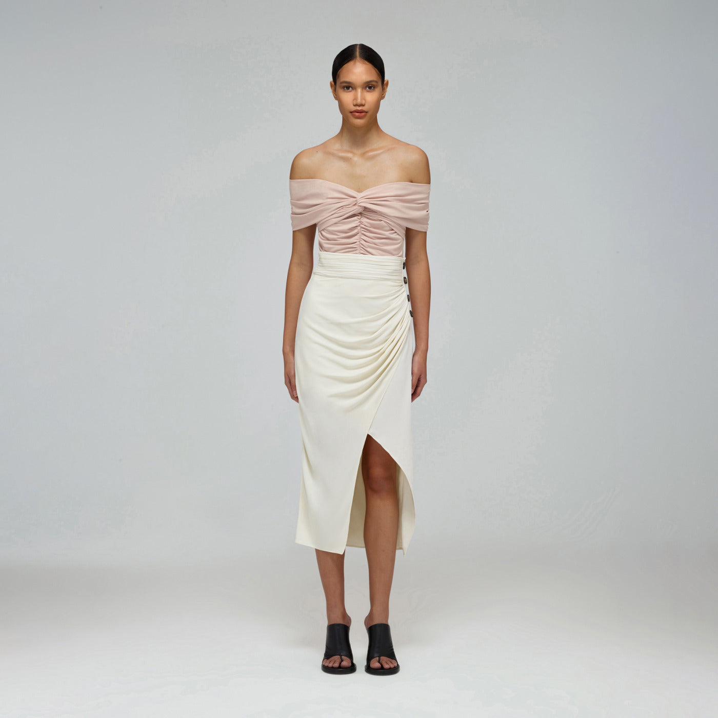 A woman wearing the Ivory Wrap Midi Skirt