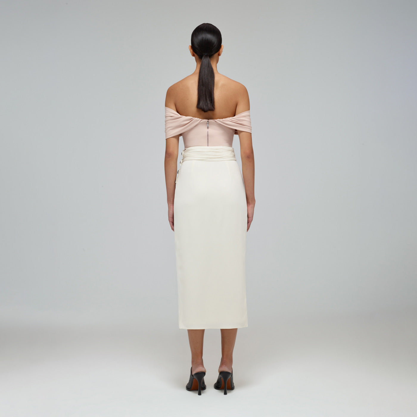 A woman wearing the Ivory Wrap Midi Skirt